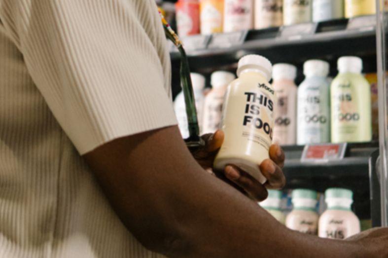 Cliente preleva una bottiglia yfood di pasto liquido pronto da uno scaffale refrigerato